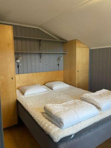 a bedroom with a large bed with white sheets and pillows at Central Apartment with Sauna & Balcony in Åre