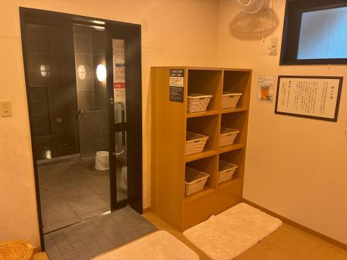 a bathroom with a closet with baskets on the shelves at Hotel Route-Inn Ashikaga Ekimae in Ashikaga