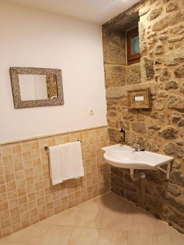 a bathroom with a sink and a stone wall at Casa Ceferinos in Muxia