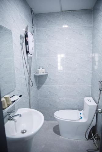 a bathroom with a white toilet and a sink at LUA Farmstay in Bà Rịa
