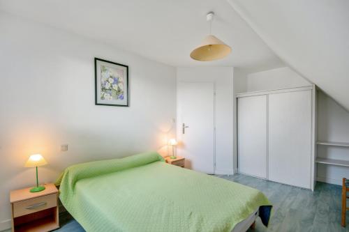 a bedroom with a green bed and two lamps at Appartement confortable avec terrasse à Arzon - 60 m² in Arzon
