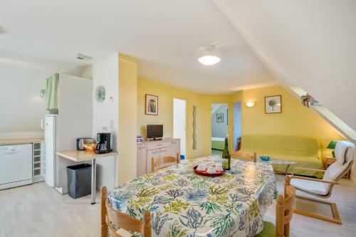 a kitchen and a dining room with a table in a room at Appartement confortable avec terrasse à Arzon - 60 m² in Arzon