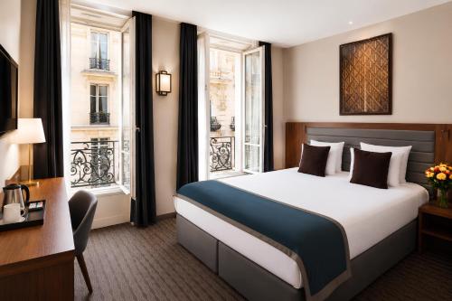 a hotel room with a bed and two windows at Hôtel Mayflower Opera in Paris