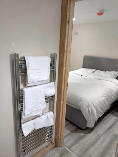 a room with a bed and a mirror with towels at The Place CABIN in Coleraine