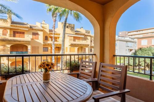 a table and chairs on a balcony with a view of a building at Spacious apartment with sea view in La Mata - 75 m² - Pool in La Mata