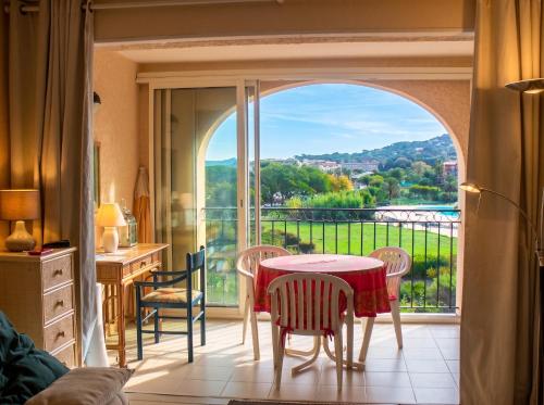 a room with a table and chairs and a balcony at Appartement convivial à Gassin 37 m² avec vue sur la mer in Gassin