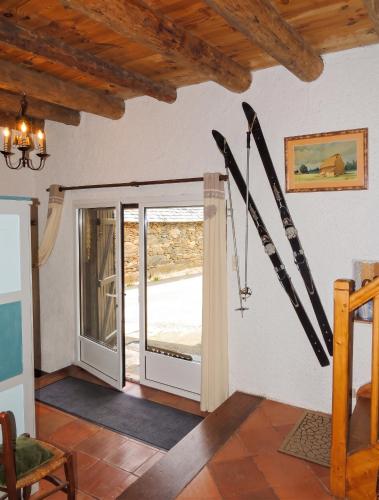 a room with skis on the wall and a sliding glass door at Maison chaleureuse à Mont >Vue montagne & cheminée in Mont