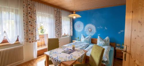 a bedroom with a table and a blue wall at Charming House in Pruggern, Mountain View in Pruggern