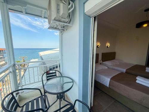 a room with a balcony with a bed and a table and chairs at Celeste Blu Suites & Rooms in Paralia Katerinis