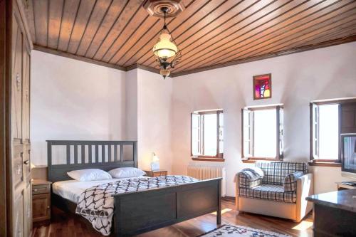 a bedroom with a bed and a couch and windows at Spacious house with sea view in Volos in Volos