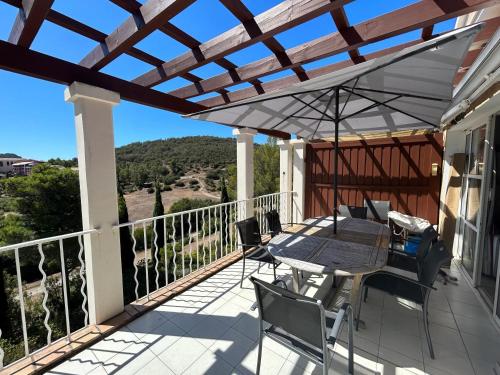 a patio with a table and chairs on a balcony at Appartement familial avec vue sur la mer à Agay - 40 m² + piscine in Agay - Saint Raphael