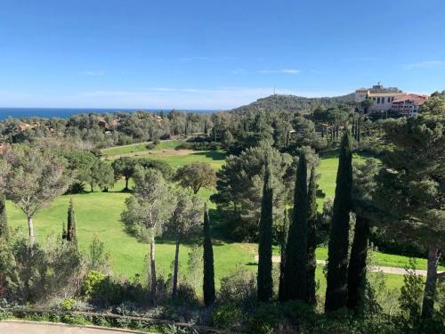 a view of a park with cypress trees at Appartement familial avec vue sur la mer à Agay - 40 m² + piscine in Agay - Saint Raphael