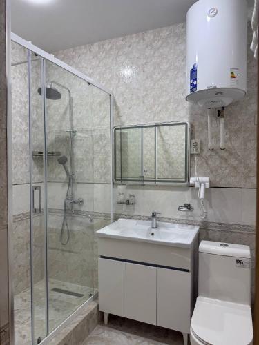 a bathroom with a shower and a sink and a toilet at Al-Amin in Termiz