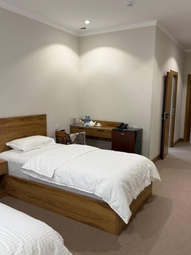 a bedroom with two twin beds and a desk at Al-Amin in Termiz