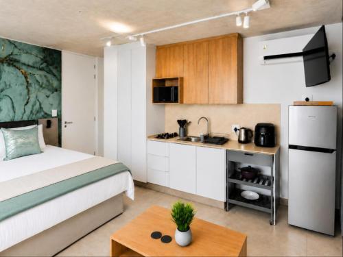 a bedroom with a bed and a small kitchen at Burleigh Ballito in Ballito