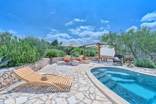 a swimming pool with two chairs and a table and a patio at Spacious House with Private Pool in Stari Grad in Stari Grad