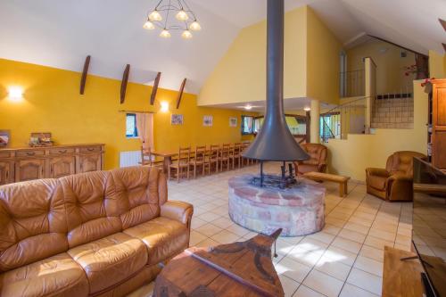 a living room with a couch and a stove at Grande maison conviviale à Saint-Côme-d'Olt avec jardin et cheminée in Saint-Côme-dʼOlt