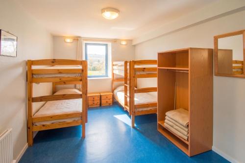 a room with three bunk beds and a window at Grande maison conviviale à Saint-Côme-d'Olt avec jardin et cheminée in Saint-Côme-dʼOlt