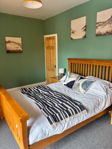 a bed in a bedroom with green walls at Maple, 3 Double Beds, Contractors Welcome in Abertillery