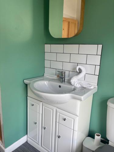 a bathroom with a white sink and a mirror at Maple, 3 Double Beds, Contractors Welcome in Abertillery