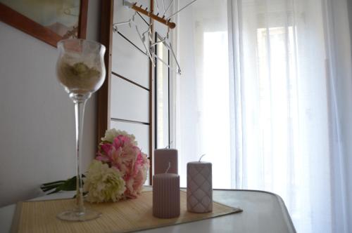 a table with a candle and a wine glass and flowers at Cozy apartment in Caltagirone - 70 m² with balcony in Caltagirone