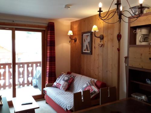 a living room with a couch and a balcony at Appartement cosy à Pelinche, Risoul - 30m² in Risoul