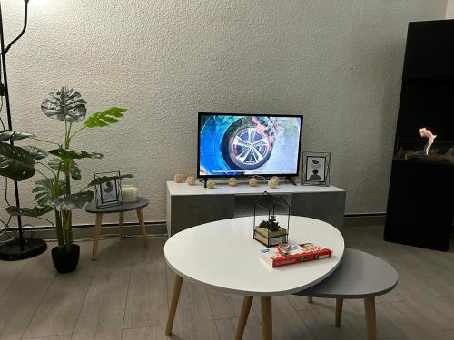 a living room with a tv and a table at Appartement charmant à Luzenac - 60m² - Confort moderne in Luzenac