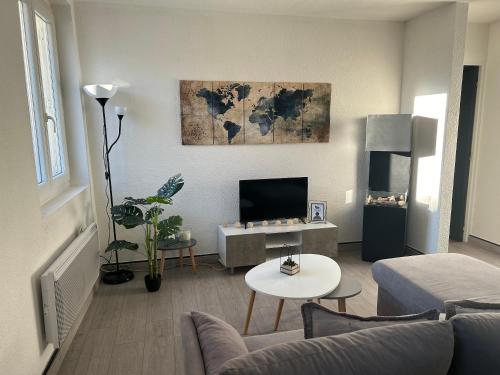 a living room with a couch and a tv at Appartement charmant à Luzenac - 60m² - Confort moderne in Luzenac