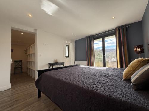 a bedroom with a large bed and a large window at Iduzki-alde bat in Souraïde