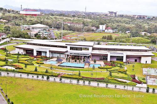 a large building with a garden in front of it at Wind Residences For Rent - Luiice in Tagaytay