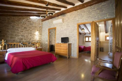 a bedroom with a bed and a television in a room at Casa rural la Posada ,Terra Alta, Matarraña. in Caseras