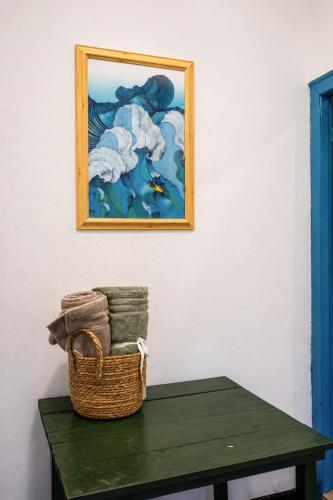 a basket on a table with a picture on the wall at Zen Yoga & Surf House in Arugam Bay