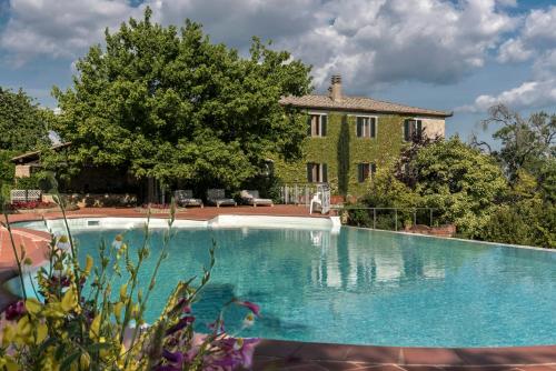 a large swimming pool in front of a house at Quaint house in Murlo with shared pool in Murlo