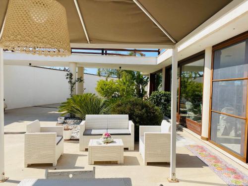a patio with white chairs and a table at Charming Apartment in Nardò with Shared Pool in Nardò