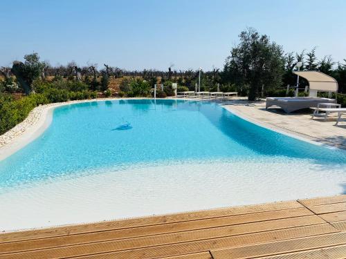 a large swimming pool with blue water at Charming Apartment in Nardò with Shared Pool in Nardò
