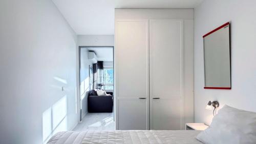 a white bedroom with a closet and a bed at Tahko North Lodge B 5 in Kuopio
