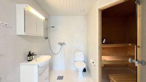 a white bathroom with a sink and a toilet at Tahko North Lodge B 5 in Kuopio
