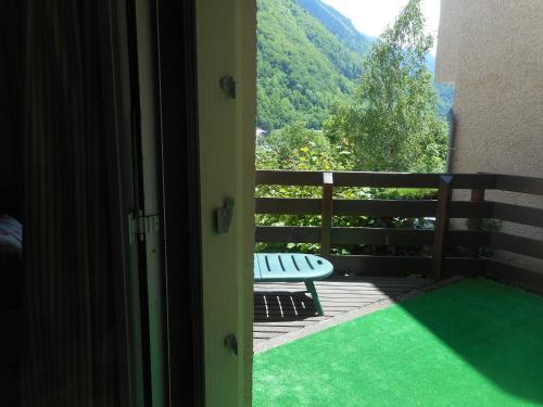 a door open to a porch with a bench on a balcony at Studio confortable à Cauterets - 40 m² - Vue sur la montagne in Cauterets