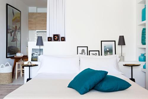 a white bed sitting in a bedroom next to a window at CBbC Suites Port Vell in Ibiza Town