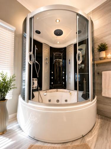 a large tub in a bathroom with a glass wall at Moonriver Guesthouse in Upington