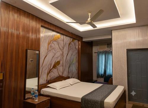 a bedroom with a bed with a painting on the wall at Ankita Guest House Dankuni in Khorel