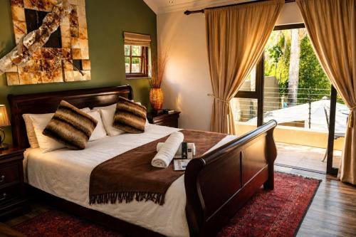 a bedroom with a large bed and a balcony at Moonriver Guesthouse in Upington
