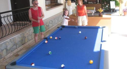 two women and a child standing next to a pool table at MG Moms Hotel in Kemer