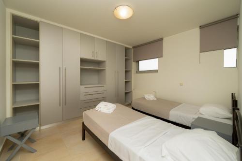 a bedroom with two beds and a desk at The peaceful escape with shared pool in Porto Rafti