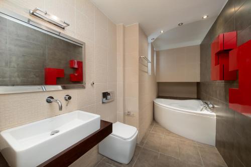 a bathroom with a sink and a tub and a toilet at The peaceful escape with shared pool in Porto Rafti