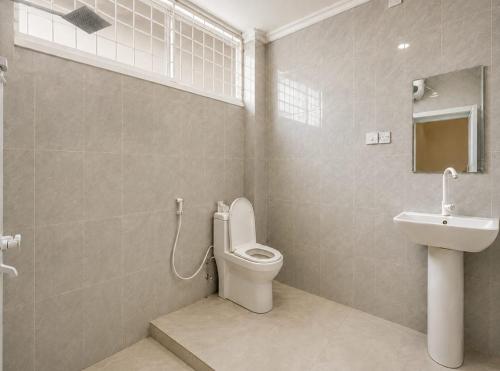 a bathroom with a toilet and a sink at City Getaway Apartment in Zanzibar City