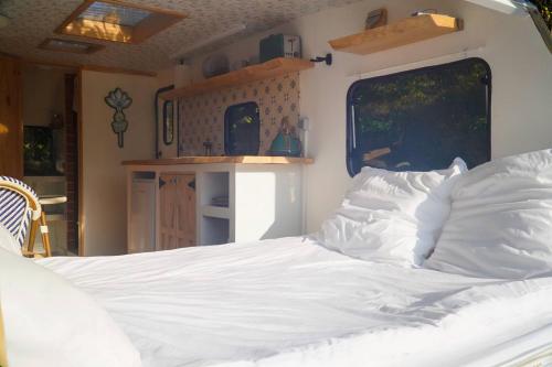 ein Schlafzimmer mit einem weißen Bett in einem Zimmer in der Unterkunft Cherry Tree Caravan in Podentes