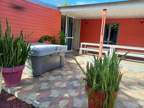 a hot tub sitting on a patio next to a house at Maison élégante à Saint-Pierre + Piscine in Casabona