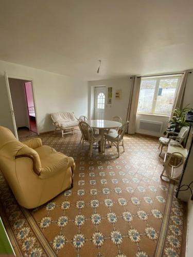 a living room with a couch and a table and chairs at Maison chaleureuse à Audignies avec stationnement privé in Audignies