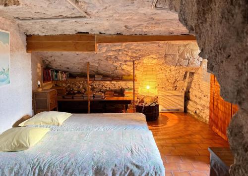 a bedroom with a bed in a stone wall at Maison charmante à Valleraugue avec piscine partagée. in Valleraugue